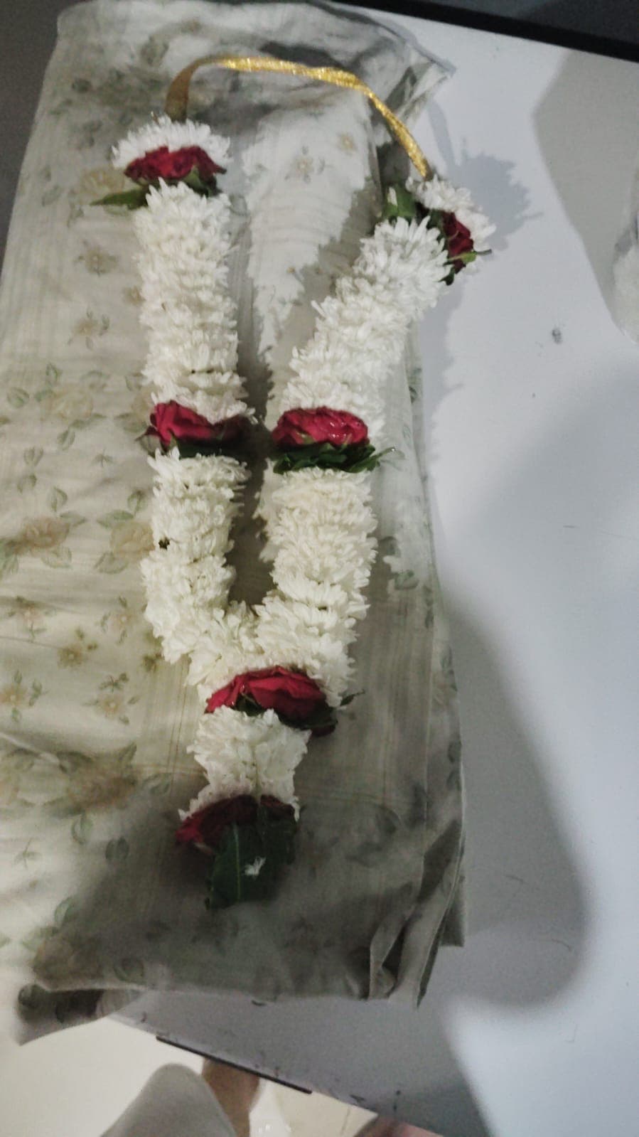 White chrysanthemum garland threaded with red roses